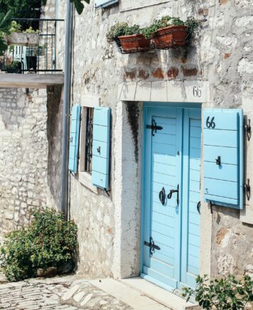 Ensemble de porte, volet et fenêtre en bois. Peint en bleu azur. Sur bâtisse en pierre ancienne.