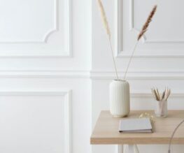 boiseries moulurées sur panneaux muraux, en avant plan une table avec des accessoires de couleurs pâle